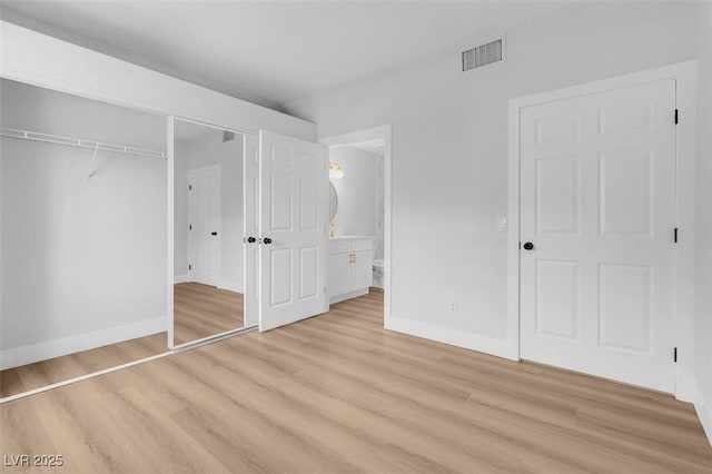 unfurnished bedroom with visible vents, baseboards, ensuite bath, light wood-style floors, and a closet