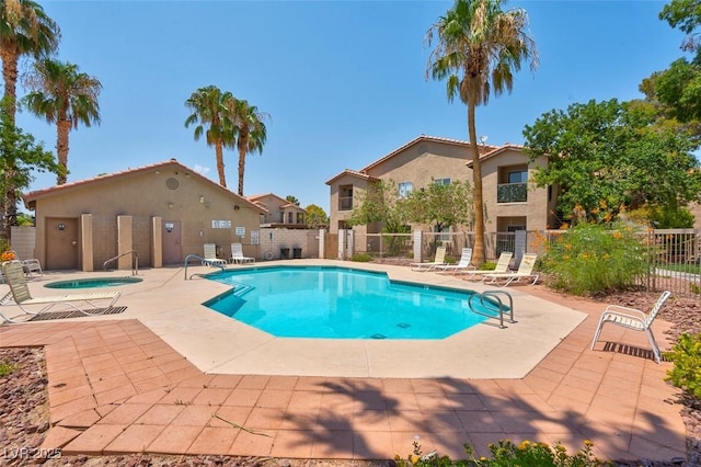 community pool featuring a patio, a community hot tub, and fence