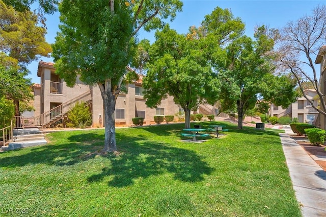 view of home's community with a yard and stairs