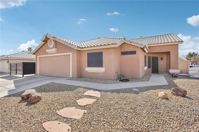 view of front facade with concrete driveway, a tiled roof, a garage, and stucco siding