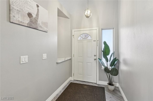 entryway with baseboards and wood finished floors