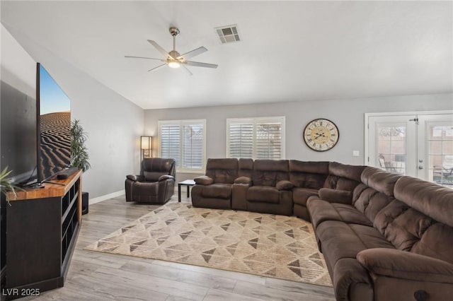 living area with visible vents, light wood-style flooring, a ceiling fan, french doors, and vaulted ceiling