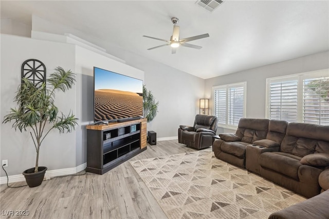 living room with visible vents, lofted ceiling, light wood-style flooring, baseboards, and ceiling fan