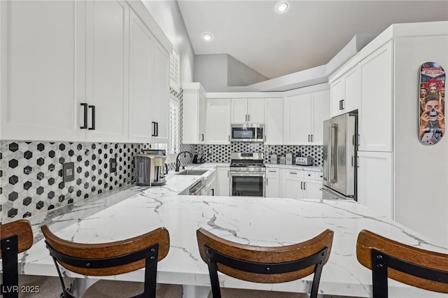 kitchen featuring tasteful backsplash, stainless steel appliances, a breakfast bar, and a sink