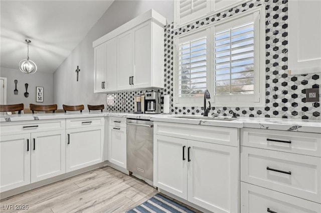 kitchen featuring white cabinetry, a sink, decorative backsplash, light countertops, and dishwasher