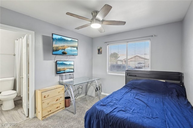 bedroom with baseboards, ensuite bath, and a ceiling fan