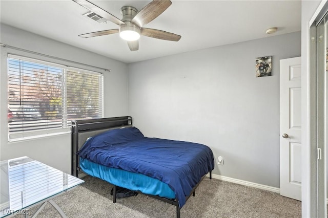 carpeted bedroom with visible vents, baseboards, and a ceiling fan