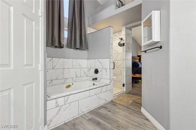 full bath featuring a shower stall, a garden tub, wood finished floors, and baseboards