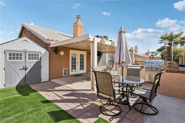 view of patio with fence, french doors, outdoor dining area, an outdoor kitchen, and a grill