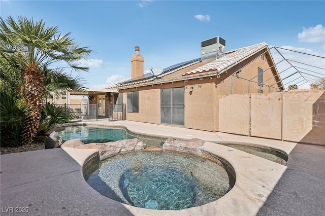 view of swimming pool with central AC, fence, a fenced in pool, an in ground hot tub, and a patio area