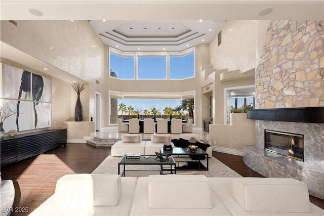 living room featuring plenty of natural light, wood finished floors, and a high end fireplace