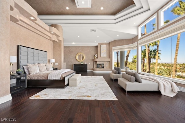 bedroom featuring visible vents, recessed lighting, a fireplace, wood-type flooring, and a raised ceiling