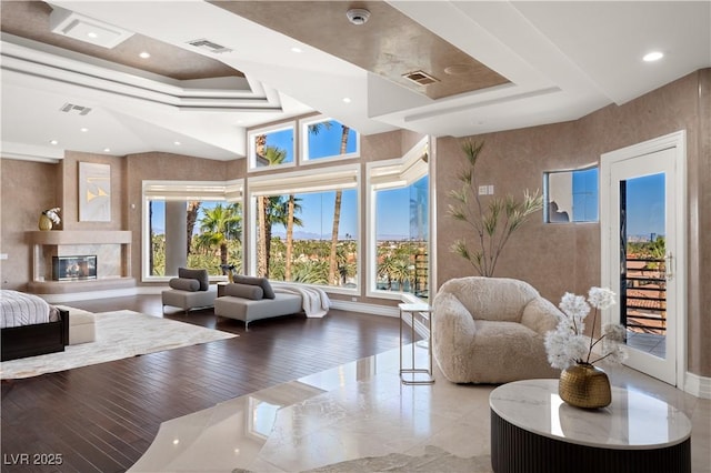 living room with recessed lighting, visible vents, and a high end fireplace