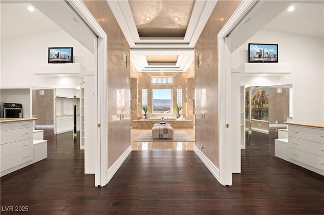 hallway with a raised ceiling, dark wood-style floors, and baseboards