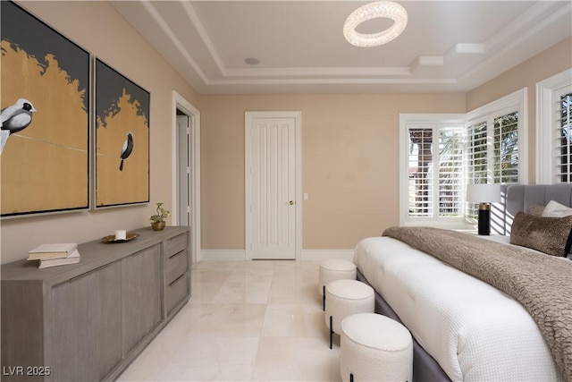 bedroom with baseboards and a raised ceiling