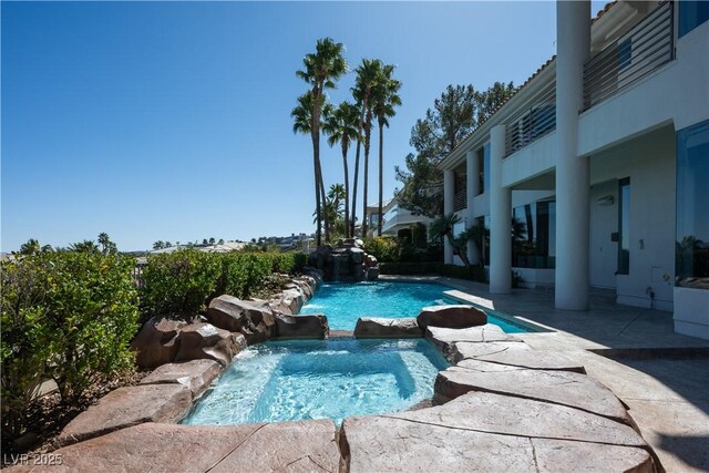 view of pool with a patio area and a pool with connected hot tub