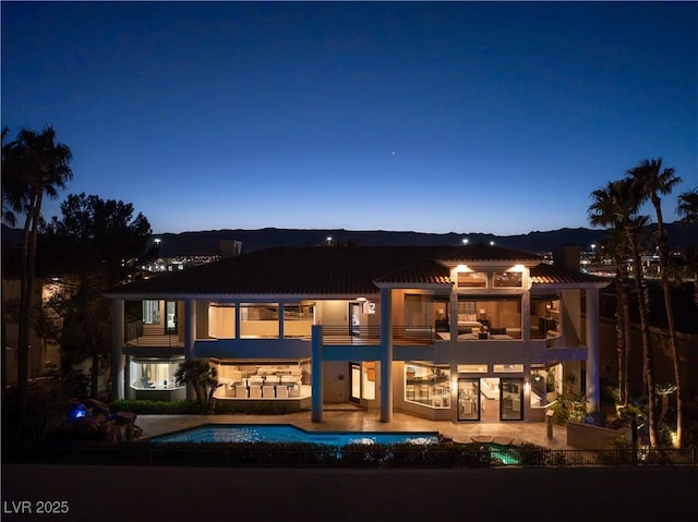 rear view of house featuring a balcony, a patio area, and an outdoor pool