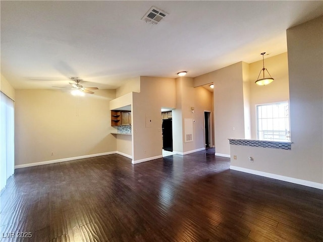 unfurnished living room with visible vents, baseboards, dark wood finished floors, and a ceiling fan