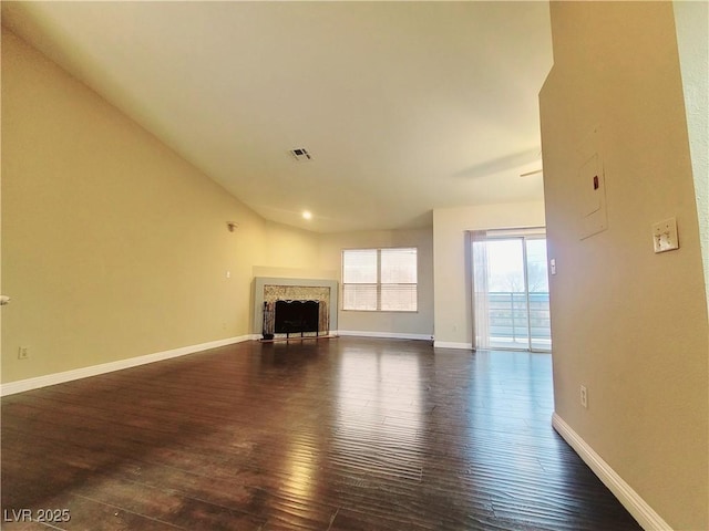 unfurnished living room with dark wood-type flooring, a fireplace, and baseboards