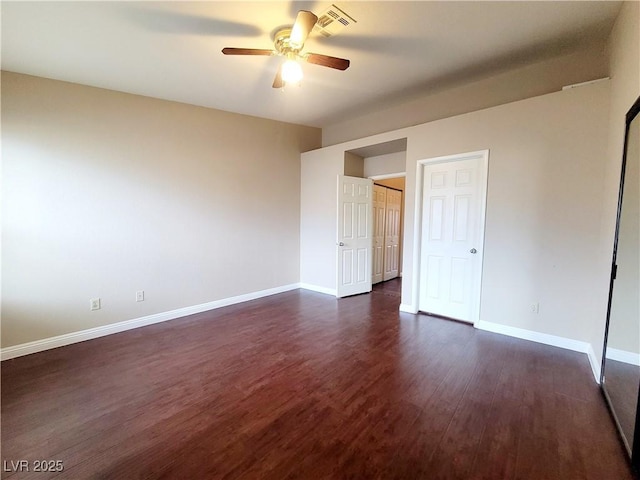 unfurnished bedroom featuring ceiling fan, visible vents, baseboards, and dark wood finished floors