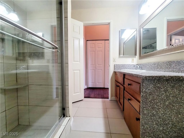 bathroom with tile patterned flooring, a stall shower, and vanity