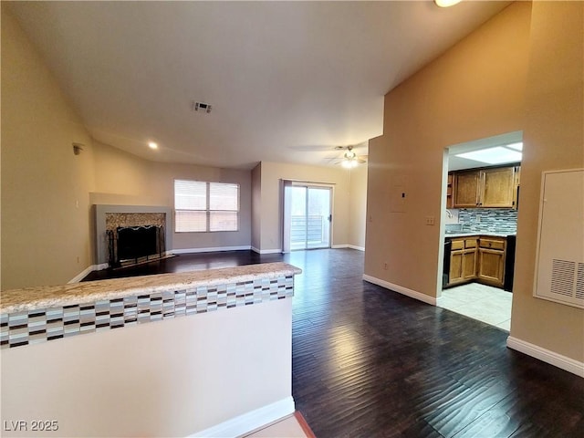 unfurnished living room featuring wood finished floors, a fireplace, visible vents, and baseboards