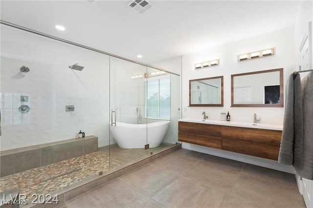 full bath featuring tile patterned flooring, visible vents, double vanity, a stall shower, and a freestanding tub