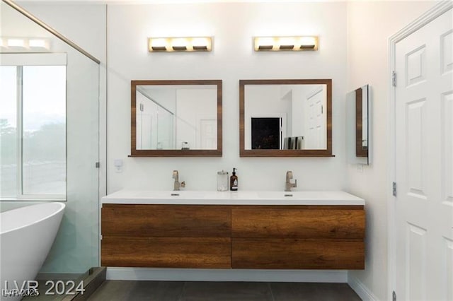 bathroom featuring a sink, double vanity, and a freestanding bath