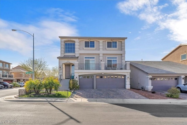 view of front of property featuring stucco siding, an attached garage, decorative driveway, and fence