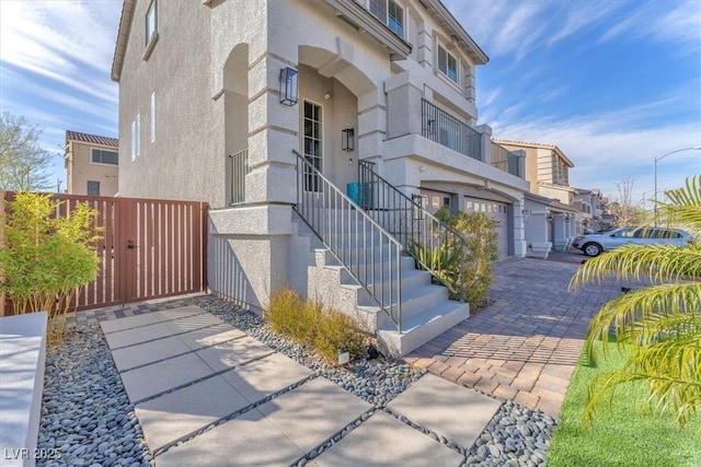 view of building exterior featuring an attached garage and decorative driveway