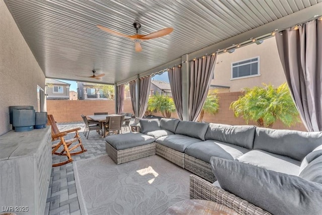 view of patio featuring ceiling fan, fence, a wall unit AC, outdoor lounge area, and outdoor dining space