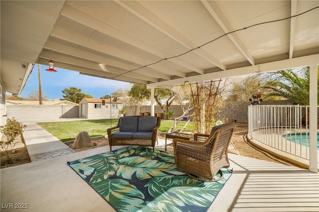 view of patio / terrace featuring outdoor lounge area, an outbuilding, and a fenced backyard