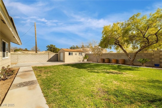 view of yard with an outbuilding, a fenced backyard, and a patio