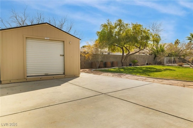 garage featuring concrete driveway and fence