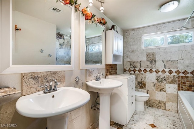 bathroom featuring curtained shower, toilet, a bathtub, tile walls, and a sink