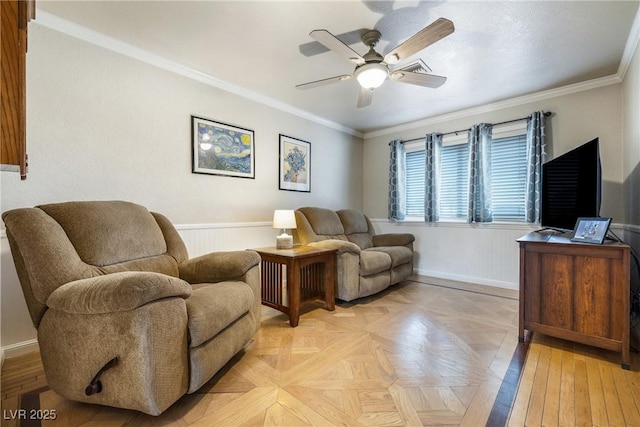 interior space with a wainscoted wall, ceiling fan, and ornamental molding