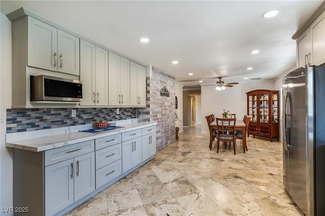 kitchen featuring recessed lighting, ceiling fan, stainless steel appliances, light countertops, and tasteful backsplash