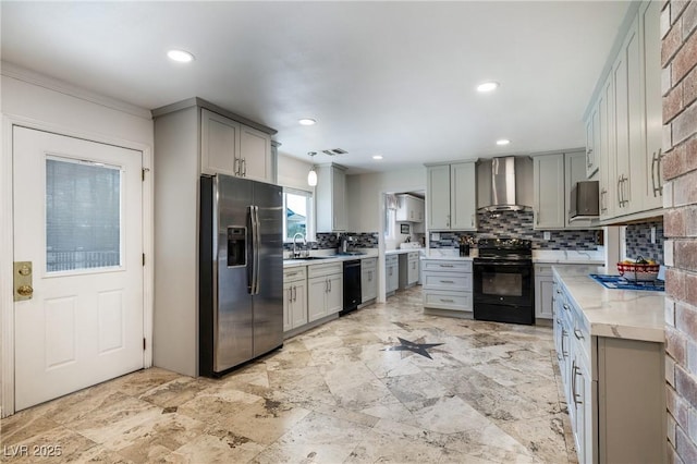 kitchen with black appliances, wall chimney exhaust hood, and gray cabinetry