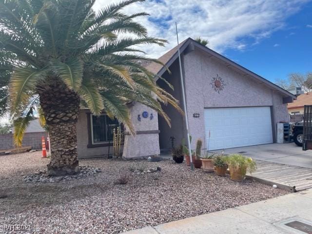 view of property exterior featuring stucco siding, concrete driveway, and a garage