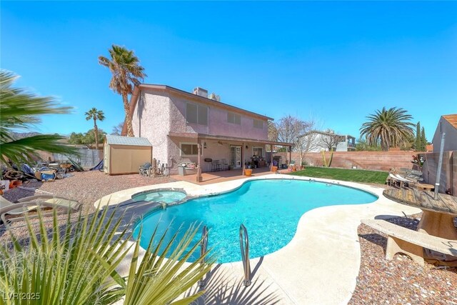 view of pool featuring a patio, a pool with connected hot tub, and a fenced backyard