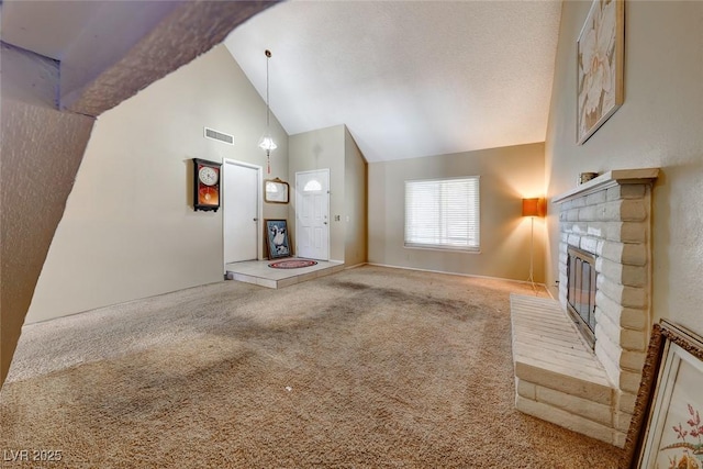 unfurnished living room featuring visible vents, carpet floors, a fireplace, a textured ceiling, and high vaulted ceiling