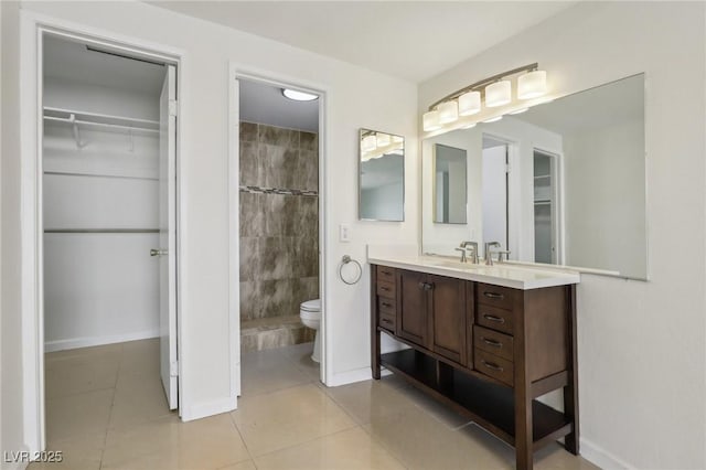 full bathroom featuring vanity, tile patterned floors, a spacious closet, and toilet