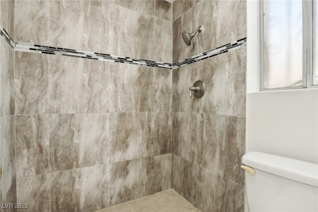 full bath with toilet and tiled shower