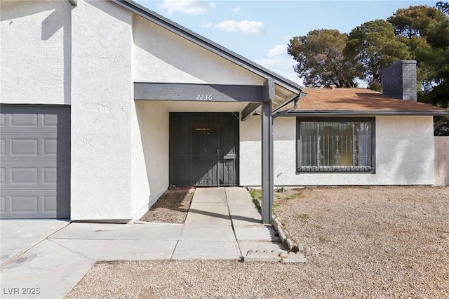 doorway to property with a chimney and stucco siding