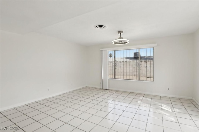 unfurnished room featuring light tile patterned floors, visible vents, and baseboards