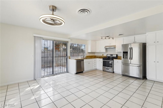 kitchen featuring visible vents, under cabinet range hood, a sink, appliances with stainless steel finishes, and white cabinets