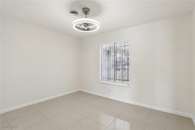 spare room featuring light tile patterned floors, visible vents, and baseboards