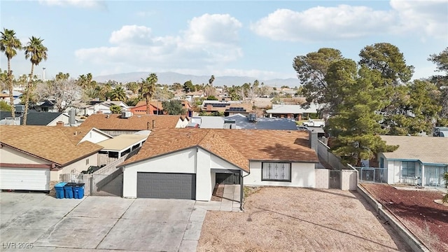 view of front of property with a residential view, stucco siding, concrete driveway, and fence