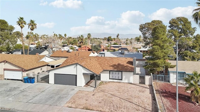 view of front of property with stucco siding, driveway, fence, a residential view, and an attached garage