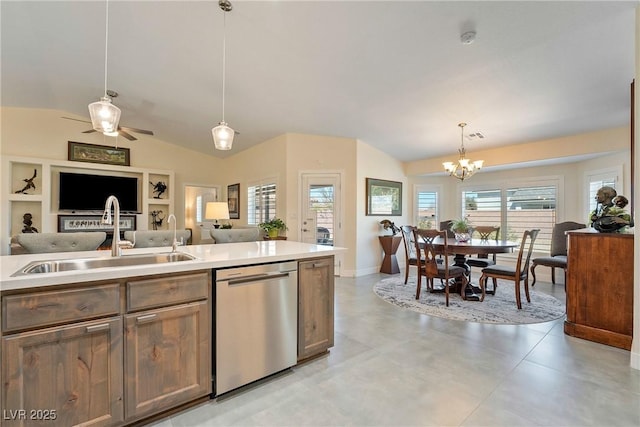 kitchen with a sink, pendant lighting, light countertops, and stainless steel dishwasher